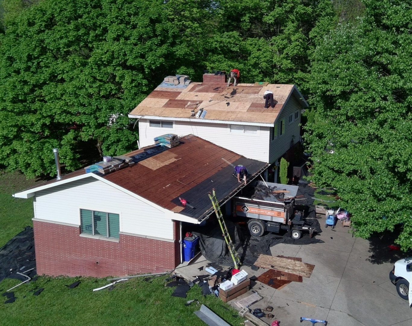 Diamond Roofing Pros using safety harnesses during a high-rise repair.