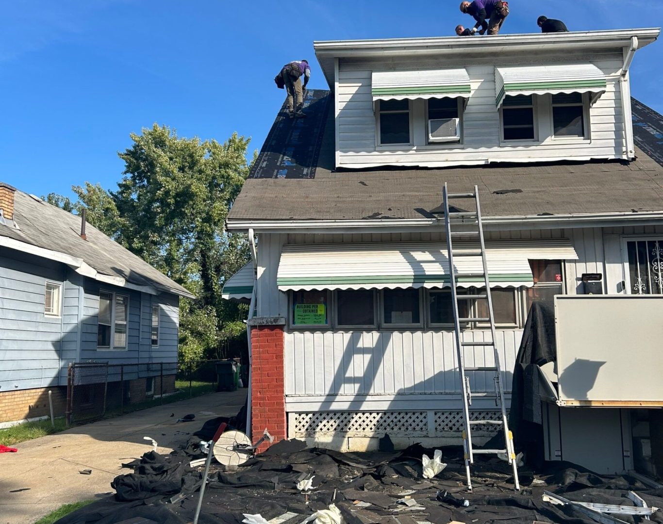 Diamond Roofing Pros crew inspecting a damaged roof after a severe storm.