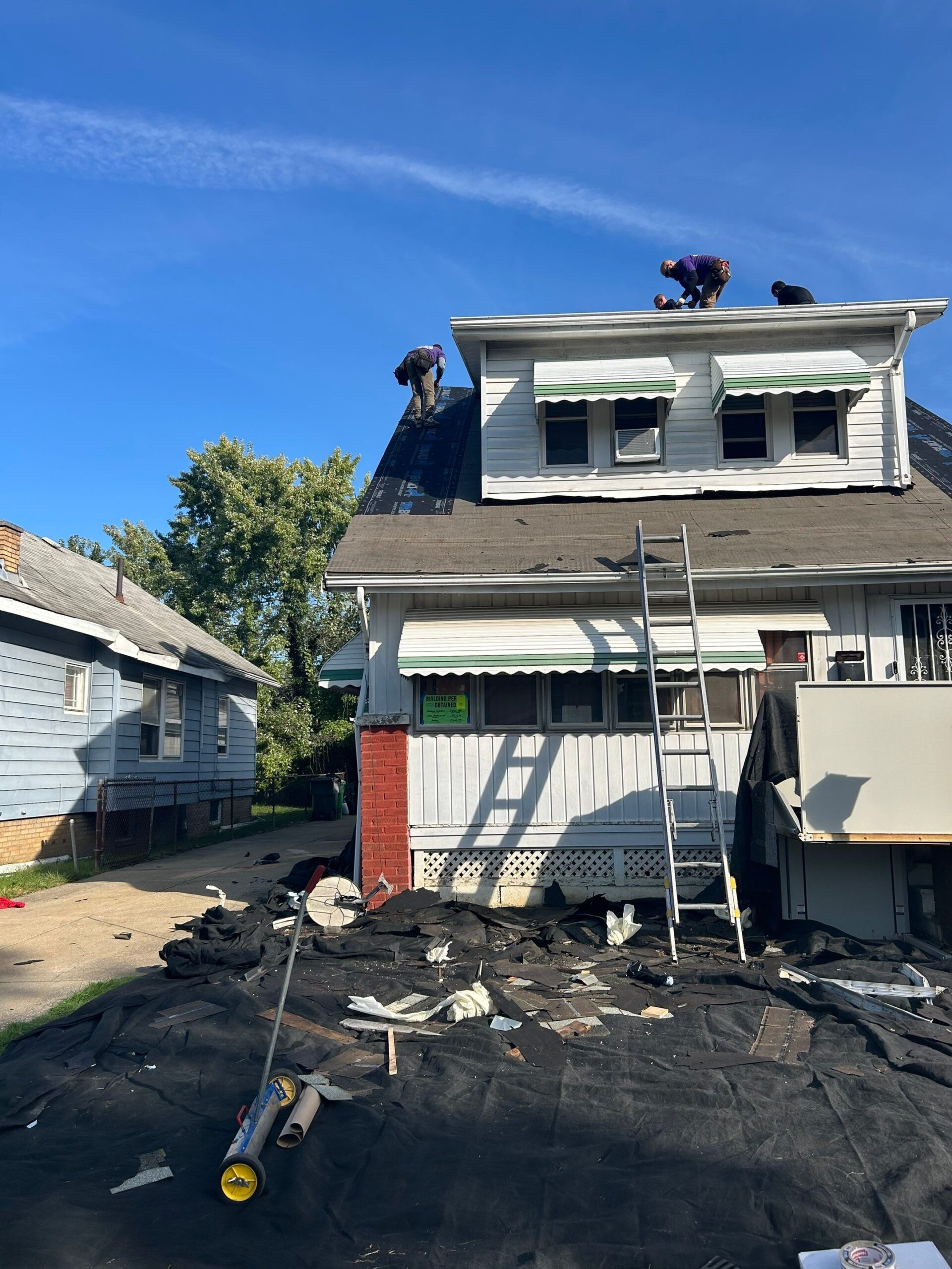 Diamond Roofing Pros crew inspecting a damaged roof after a severe storm.